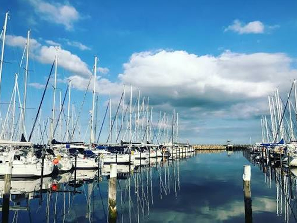 Segelboote und spiegelndes Wasser im Grömitzer Yachthafen